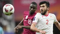 Pemain Qatar, Almoez Ali, berebut bola dengan pemain Tajikistan, Zoir Dzhuraboev, pada laga Grup A Piala Asia di Stadion Al Bayt , Rabu (17/1/2024). (AP Photo/Aijaz Rahi)