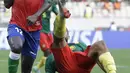 Bek Gambia James Gomez melakukan pertahanan saat bersaing dengan bek Kamerun JC Castelletto pada pertandingan perempatfinal Piala Afrika 2021 di Japoma Stadium, Minggu (30/1/2022) dini hari WIB. Kamerun melangkah ke semifinal usai menang atas Gambia, 2-0. (AP Photo/Sunday Alamba)