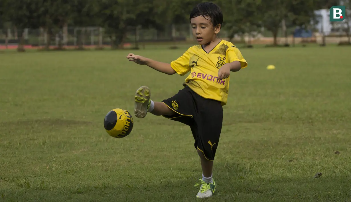 Anak dari Stefano Teco, yang bernama Romario, menendang bola saat latihan Persija Jakarta di Lapangan Sutasoma, Jakarta, Minggu (25/2/2018). Ketika ayahnya bekerja sang anak asyik bermain sepak bola. (Bola.com/Aspirilla Dwi Adha)