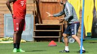 Pelatih Bayern Munchen Josep Guardiola memberikan instruksi kepada bek Jerome Boateng, dalam sesi latihan, di Munchen, 27 Juli 2015. (AFP PHOTO / CHRISTOF STACHE)