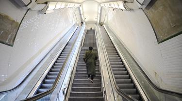 Seorang komuter berjalan di lantai atas di stasiun metro-RER Saint-Lazare di Paris selama aksi pemogokan massal, Kamis (10/11/2022). Pekerja kereta komuter di ibu kota Prancis melakukan pemogokan massal dan menuntut kenaikan gaji. (Bertrand GUAY / AFP)