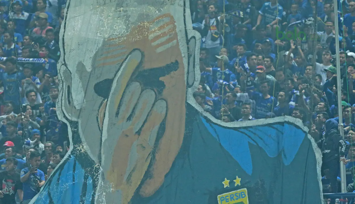 Koreografi Bobotoh menampilkan pelatih Roberto Mario Gomez saat mendukung Persib Bandung melawan Mitra Kukar pada laga Liga 1 Indonesia 2018 di Stadion GBLA, Bandung, Jawa Barat, Minggu (8/4/2018). Persib Bandung menang 2-0. (Bola.com/Nick Hanoatubun)