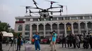 Petugas Administrasi Metropolitan Bangkok (BMA) melihat demonstrasi drone untuk menurunkan hujan buatan, Kamis (31/1). Thailand mengerahkan drone untuk menyemprotkan air dalam membantu memerangi polusi udara di Ibu Kota yang makin parah. (Jewel SAMAD/AFP)