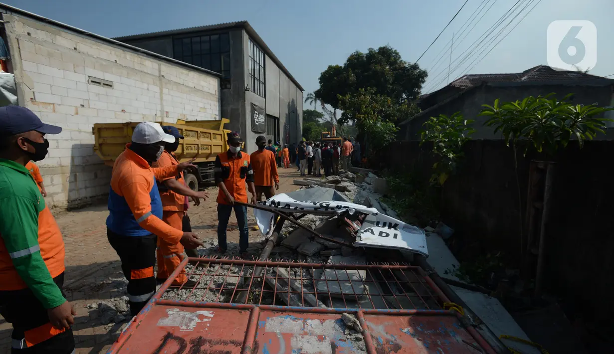 Para pekerja merobohkan pagar beton yang mengisolasi sejumlah warga di Jalan Akasia, Tajur Ciledug, Tangerang, Banten, Rabu ( 17/3/2021). Pagar beton yang sempat menutup akses jalan warga tersebut kini dibongkar. (merdeka.com/Imam Buhori)