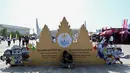 Untuk menghindari sengatan sinar matahari, seorang pria bernaung di bawah naungan papan nama Pesta Olahraga Asia Tenggara (SEA Games) ke-32 di luar Stadion Nasional Morodok Techo menjelang upacara pembukaan acara tersebut di Phnom Penh pada tanggal 5 Mei 2023. (NHAC NGUYEN/AFP)