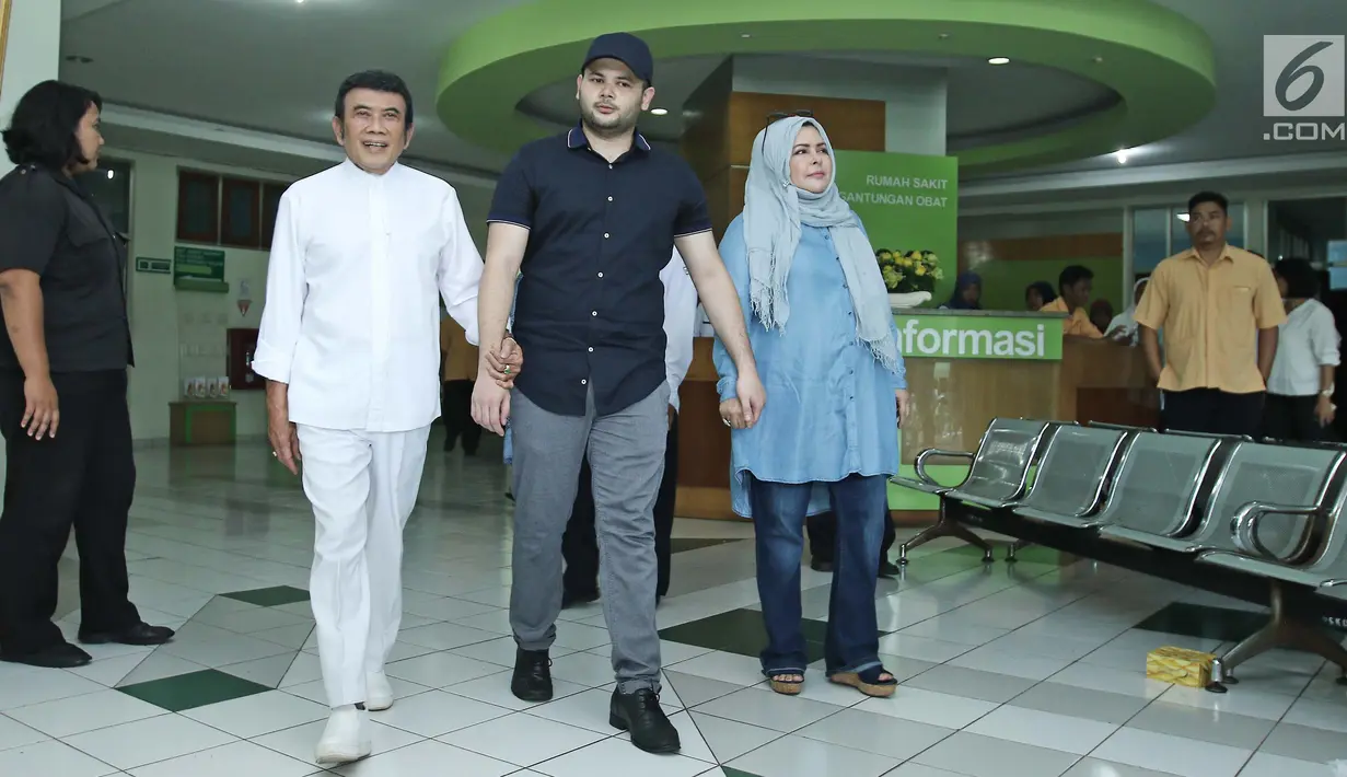 Ridho Rhoma (tengah) didampangi sang ayah, Rhoma Irama dan istrinya meninggalkan Rumah Sakit Ketergantungan Obat (RSKO), Jakarta, Kamis (25/01). Rhoma Irama berharap anaknya sembuh total dari ketergantungan narkoba. (Liputa6.com/Herman Zakharia)