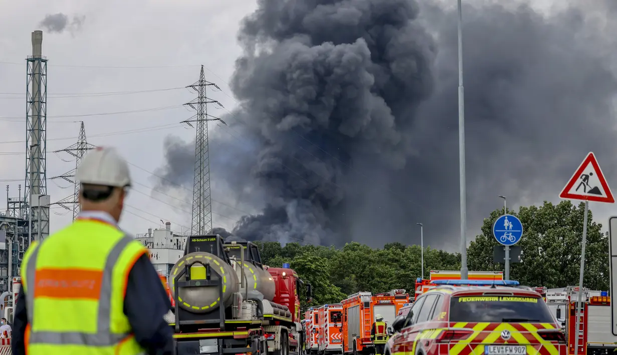 Kendaraan darurat pemadam kebakaran, layanan penyelamatan dan polisi terlihat tidak jauh dari lokasi ledakan di kawasan industri kimia di Leverkusen, Jerman (21/7/2021).  Warga diperintahkan untuk menutup pintu dan jendela serta menyimpan nomor darurat sebanyak mungkin. (AP Photo/Oliver Berg)