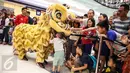 Anak-anak memegang barongsai sambil memberikan angpao usai atraksi Barongsai Tonggak di Lippo Mall Puri, Jakarta Barat, (21/01). (Liputan6.com/Fery Pradolo)