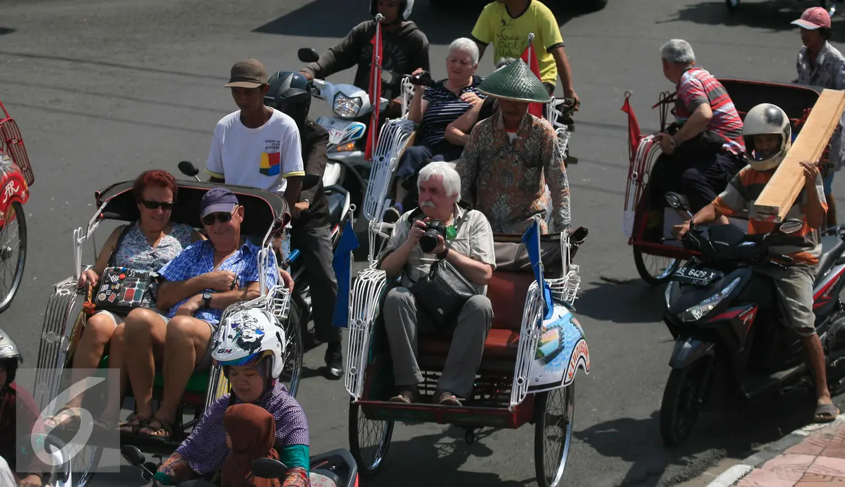 Seorang turis mengabadikan gambar dari atas becak saat mengelilingi alun alun Kraton Kesultanan Yogyakarta, (4/5). Becak menjadi transportasi ramah lingkungan yang di minati wisatawan karena tidak menimbulkan polusi udara. (Liputan6.com/Boy Harjanto)