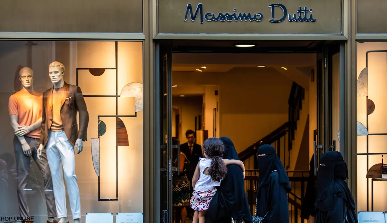 Sejumlah wanita yang mengenakan niqab berjalan melewati toko Massimo Dutti di Istanbul, 13 Agustus 2018. Bagi sebagian wisatawan asing, Turki kini jadi destinasi belanja termurah untuk berbagai produk keluaran brand high-end. (AFP/Yasin AKGUL)