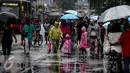 Sejumlah warga menggunakan jas hujan saat menghadiri Car Free Day di Bundaran HI, Jakarta, Minggu (13/11). Meski gerimis di kawasan tersebut mereka tak surut untuk berolahraga. (Liputan6.com/Faizal Fanani)