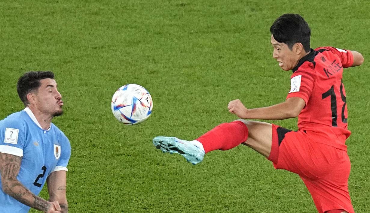 Pemain Uruguay, Jose Gimenez (kiri) berebut bola dengan pemain Korea Selatan Lee Kang-in. (AP Photo/Pavel Golovkin)