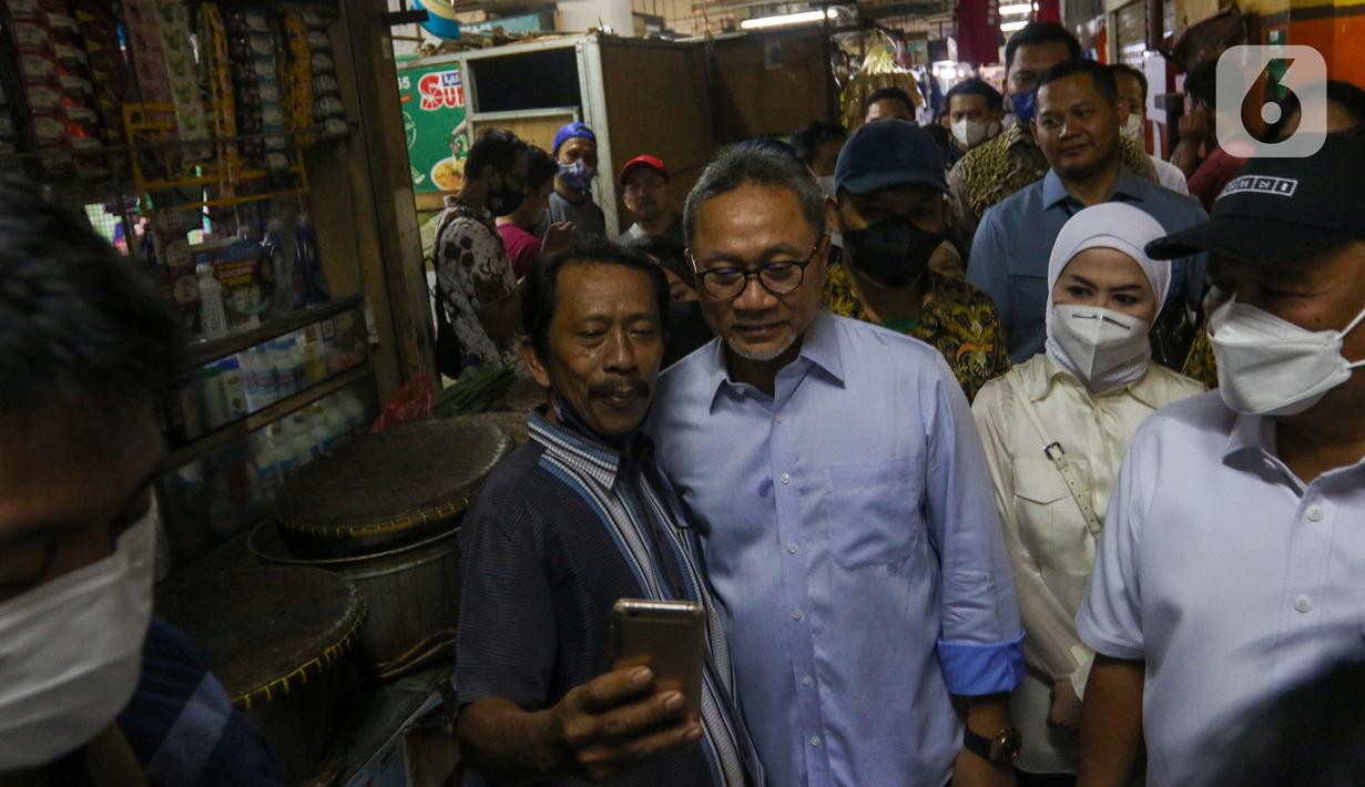Menteri Perdagangan Zulkifli Hasan (tengah) berfoto dengan warga saat meninjau harga bahan pokok di Pasar Cibubur, Jakarta, Kamis (16/6/2022). Kunjungan tersebut dilakukan untuk melihat dan memantau langsung harga bahan pokok guna memastikan harga stabil menjelang Hari Raya Idul Adha 1443 Hijriah. (Liputan6.com/Herman Zakharia)
