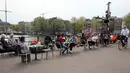 Pelanggan duduk di teras sebuah kafe di samping kanal di Amsterdam, Rabu (28/4/2021). Pemerintah Belanda mulai melonggarkan pembatasan ketat terkait Covid-19, mengakhiri jam malam yang kontroversial dan mengizinkan kafe untuk buka di luar ruangan. (François WALSCHAERTS/AFP)