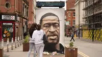 Warga mengamati mural George Floyd di Manchester tengah, Inggris (4/6/2020). George Floyd tewas kehabisan napas saat dalam penahanan pihak kepolisian Negara Bagian Minnesota, wilayah Midwest Amerika Serikat, pada pekan lalu. (Xinhua/Jon Super)