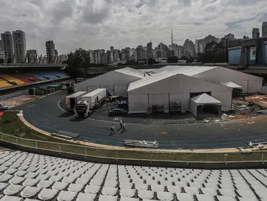 Orang-orang bekerja di lokasi pembangunan rumah sakit sementara di kompleks olahraga Ibirapuera di tengah merebaknya COVID-19 di Sao Paulo (16/4/2020). Jumlah kasus terkonfirmasi COVID-19 di Brasil melonjak dari 28.320 menjadi 30.425, kata Kemenkes Brasil pada Kamis (16/4). (Xinhua/Rahel Patrasso)