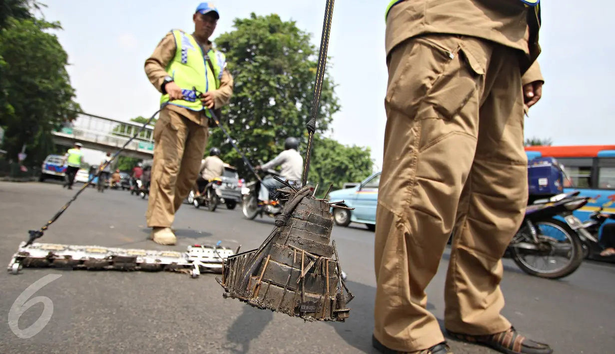 Tim Saber membersihkan Jalan Kyai Tapa, Jakarta, dari ranjau paku, Jumat (6/11). Kegiatan ini dilakukan untuk membersihkan jalan dari ranjau paku yang disebarkan oknum tak bertanggung jawab. (Liputan6.com/Immanuel Antonius)