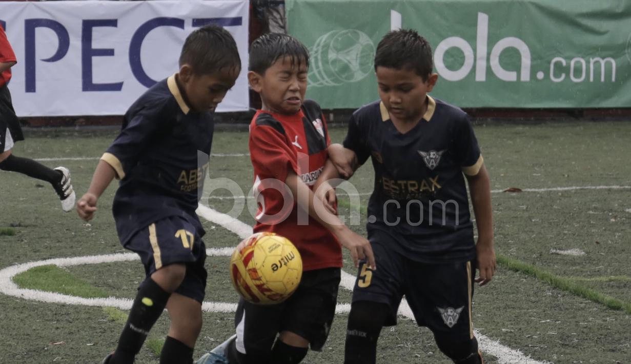 Pemain Serpong City (merah) berebut bola dengan pemain Abstrax FA dalam final Plate U-10 Serpong City International Soccer Tournament di Sabnani Park, Tangerang Selatan. Minggu (4/12/2016). (Bola.com/Arief Bagus)