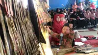 Dibanding dengan tokoh wayang yang berjejer di kelir, tubuh Ki Catur Putra Sinatria tenggelam. Namun, tangannya lincah memainkan beragam tokoh wayang. (Liputan6.com/Muhamad Ridlo).