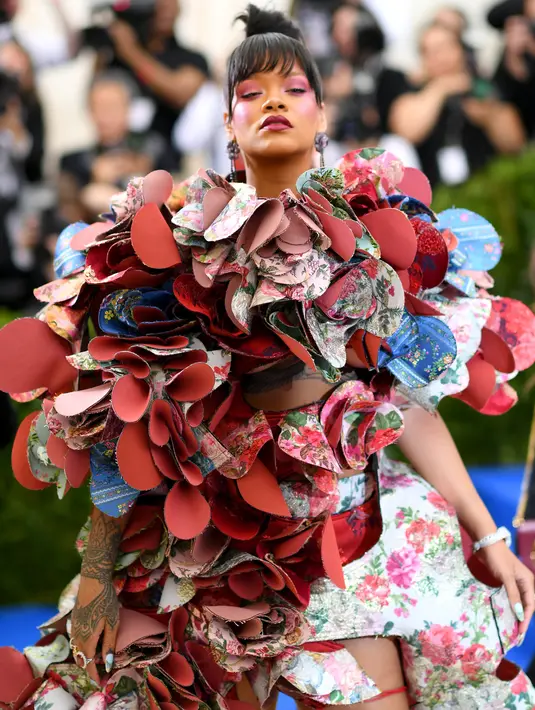 Penyanyi Rihanna berpose untuk fotografer setibanya di acara penggalangan dana Met Gala 2017, New York, Senin (1/5). Menyesuaikan tema Comme des Garcons, Rihanna tampil unik lewat gaun aksen bunga rancanangan Rei Kawakubo. (Dimitrios Kambouris/AFP)