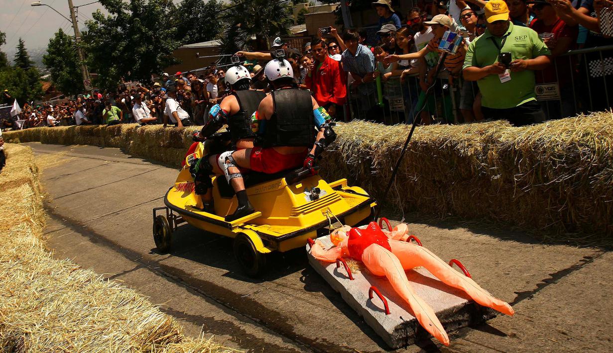 Peserta menaiki kendaraan buatannya melewati salah satu rintangan ajang balap mobil 'Kotak sabun' Red Bull Soapbox di Santiago, Chili, Minggu (27/11). Dalam ajang ini, setiap kendaraan dibuat berbentuk kotak layaknya tempat sabun. (REUTERS/Jonathan Faus)