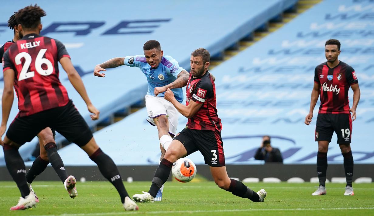 Striker Manchester City, Gabriel Jesus, melepaskan tendangan ke arah gawang Bournemouth, Jack Stacey, pada laga lanjutan Premier League pekan ke-36 di Etihad Stadium, Kamis (16/7/2020) dini hari WIB. Manchester City menang 2-1 atas Bournemouth. (AFP/Dave Thompson/pool)