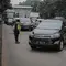 Anggota polisi melakukan penindakan kepada sebuah kendaraan saat ganjil genap di kawasan Jalan D.I Panjaitan, Jakarta, Senin (6/6/2022). Pembatasan mobil dengan sistem pelat nomor ganjil genap di Jakarta diperluas menjadi 25 titik mulai hari ini, Senin, 6 Juni 2022. (Liputan6.com/Faizal Fanani)