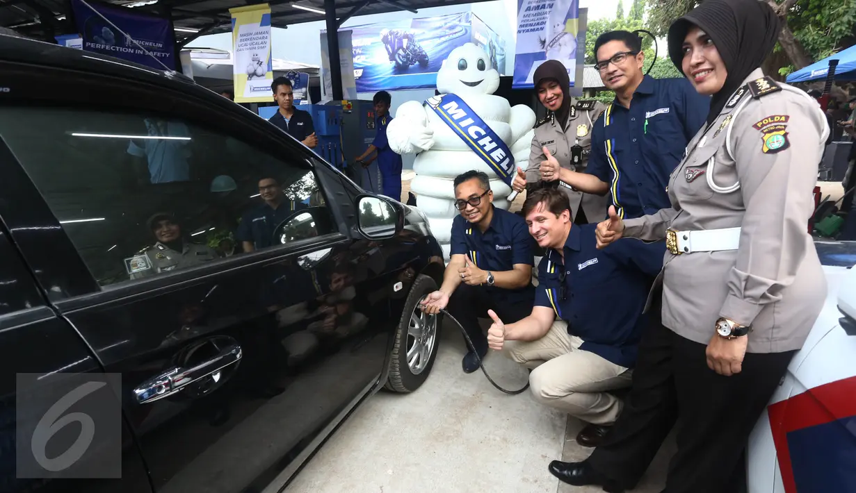 Presdir. PT Michelin Indonesia Pascal Nouvellon (ketiga kanan) dan Kasubdit Dikyasa Ditlantas Polda Metro Jaya AKBP Agustin Susilowati saat mengisi ban mobil di Jakarta, Rabu (15/6). (Liputan6.com/Angga Yuniar)