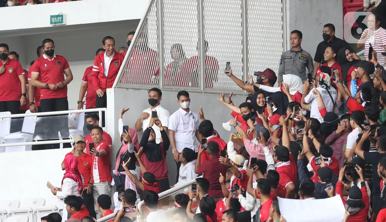 Presiden Joko Widodo menyapa supporter saat jeda laga timnas Indonesia melawan Thailand pada lanjutan kualifikasi Grup A Piala AFF 2022 di Stadion Utama Gelora Bung Karno, Jakarta, Kamis (29/12/2022). Laga berakhir imbang 1-1 meski Indonesia sempat unggul lewat gol yang dicetak Marc Anthony Klok lewat titik putih. (Liputan6.com/Helmi Fithriansyah)