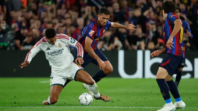 Pemain Real Madrid Jude Bellingham (kiri) berebut bola dengan pemain Barcelona Rodri