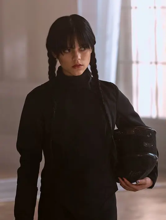 Semua pakaian yang dikenakan Jenna saat menjadi Wednesday pasti berwarna monokrom. Gambar ini merupakan salah satu scene saat Wednesday mengikuti ekstrakurikuler anggar di sekolahnya, pakaian anggar yang umumnya berwarna putih dibuat menjadi hitam untuk Wednesday. (Instagram/@diet_prada/@netflix)