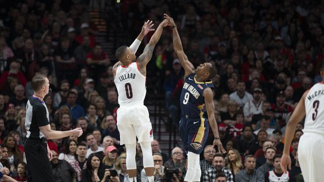 Rajon Rondo (kanan) berduel dengan Damian Lillard saat Pelicans bertemu Blazers pada gim pertama play-off NBA