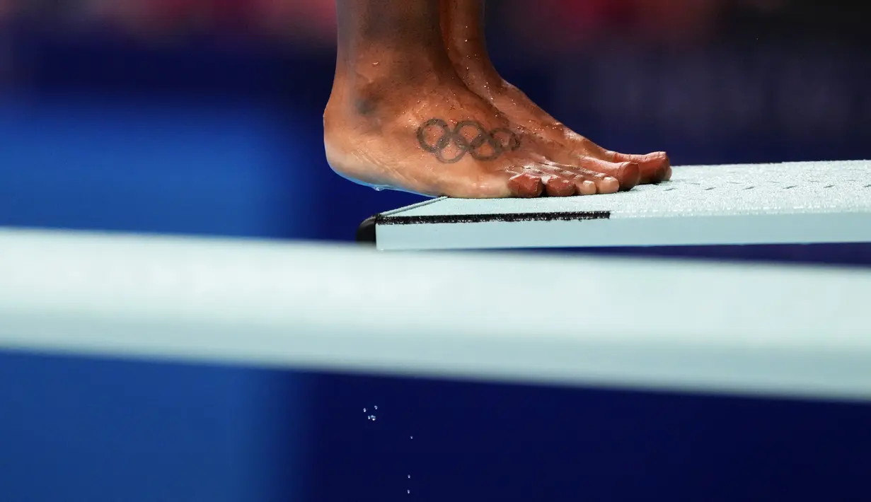 Sebuah tato cincin Olimpiade menghiasi kaki Jennifer Abel, dari Kanada, saat ia bersiap untuk menyelam di babak penyisihan loncatan 3 meter loncatan putri di Olimpiade Musim Panas 2020 di Tokyo, Jepang, Jumat (30/7/2021). (AP Photo/David Goldman)