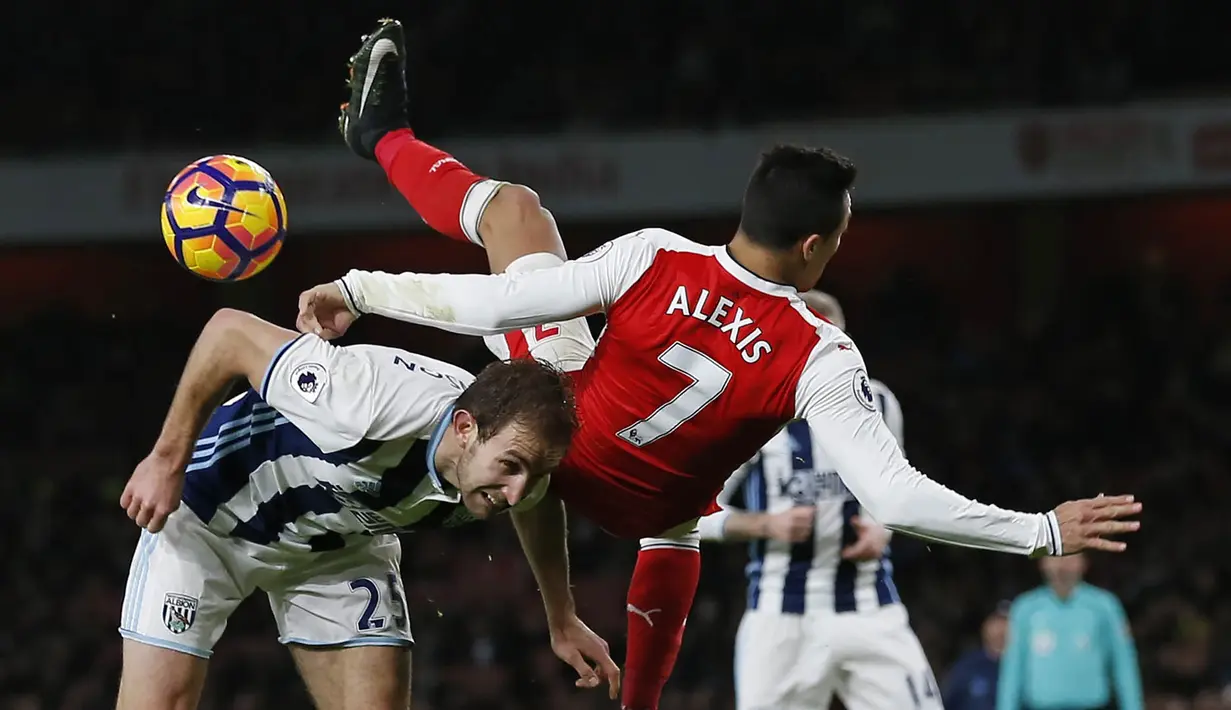 5. Penyerang Arsenal, Alexis Sanchez, terjatuh saat berebut bola dengan bek West Bromwich Albion, Craig Dawson, pada laga Premier League di Stadion Emirates, Inggris, Senin (26/12/2016). (AFP/Ian Kington)