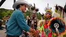 Perdana Menteri Kanada Justin Trudeau bersalaman dengan penari pribumi setempat dalam acara Calgary Stampede di Calgary, Alberta, Kanada (15/7). Festival dan pameran ini diadakan setiap bulan Juli di Calgary. (Jeff McIntosh / The Canadian Press via AP)