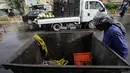 Seorang pekerja melihat tempat sampah yang berisi sisa-sisa pembom bunuh diri yang melakukan pengeboman semalam di Syiah Baghdad di al-Shoala (24/5). (AFP Photo/Ahmad Al-Rubaye)