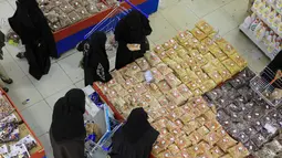 Warga Yaman membeli permen dan kacang-kacangan saat umat Islam bersiap untuk merayakan liburan tahunan Idul Adha (Hari Raya Kurban) di supermarket di ibu kota Sanaa (18/7/2021). (AFP/Mohammed Huwais)
