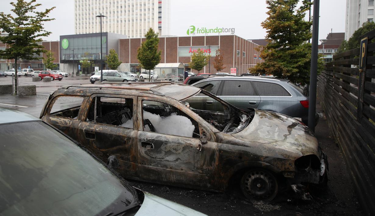 Kondisi mobil yang rusak dan hangus terbakar oleh orang tak dikenal di kota Gothenburg, Swedia, Selasa (14/8). PM Swedia Stefan Lofven menyebut tindak pembakaran dan pengrusakan mobil itu gerakan yang terorganisir. (Henrik BRUNNSGARD/TT News Agency/AFP)