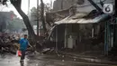 Warga berjalan melewati toko dan pemukiman yang terbakar di kawasan Manggarai, Jakarta, Selasa (7/7/2020). Hingga kini belum diketahui pengebab kebakaran. (Liputan6.com/Immanuel Antonius)