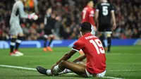 Striker Manchester United, Marcus Rashford duduk di lapangan setelah gagal mencetak gol ke gawang Sevilla pada laga leg kedua 16 besar Liga Champions di Old Trafford, Selasa (13/3). Manchester United menyerah 1-2 kepada tamunya Sevilla. (Oli SCARFF/AFP)