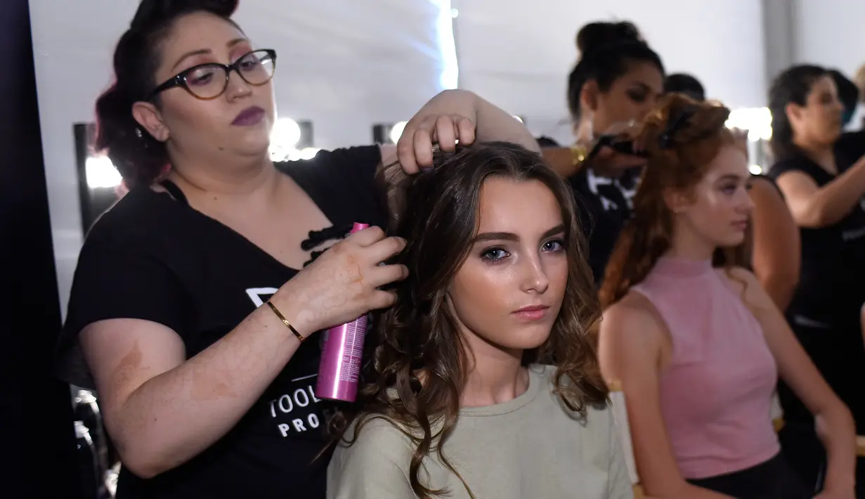 Seorang model saat ditata rambutnya di belakang panggung jelang tampil dalam Peragaan Busana Renang, Art Hearts Fashion Miami Swim Week di Collins Park, Miami, Florida, (14/7). (Arun Nevader/Getty Images Seni Hati Mode/AFP)