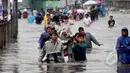 Sejumlah warga terpaksa menggunakan jasa gerobak untuk melintasi banjir yang setinggi dada orang dewasa di Jalan Gunung Sahari, Jakarta, Senin (6/2/2015). (Liputan6.com/Faizal Fanani)