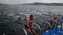 Atlet keluar dari air setelah mengikuti lomba renang dari Asia hingga Eropa di Selat Bosphorus ke-30, Istanbul, Turki, (22/7). Lebih dari 2.000 peserta terjun dari feri dan berenang sejauh sekitar 6,5 km di acara tersebut. (AP Photo/Lefteris Pitarakis)