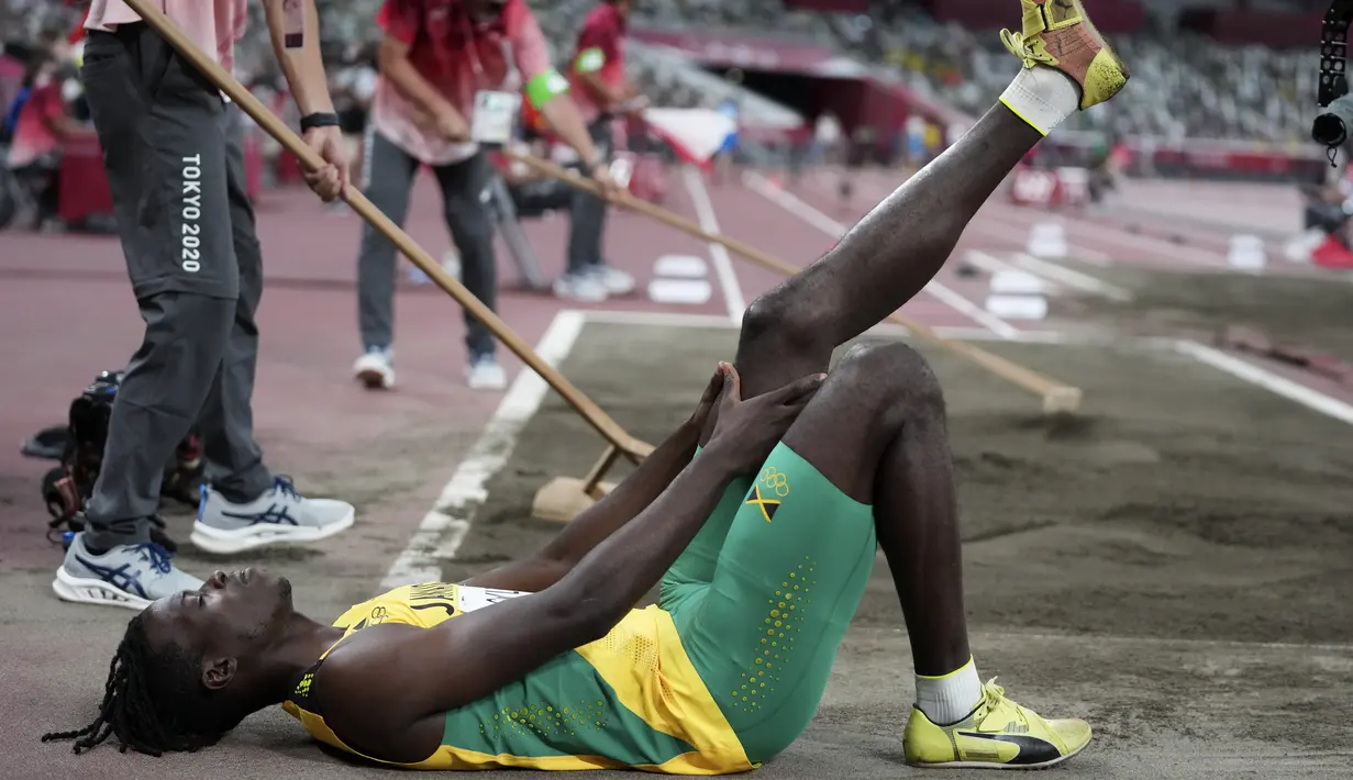 Tajay Gayle, dari Jamaika, meregangkan kakinya selama babak kualifikasi lompat jauh putra di Olimpiade Musim Panas 2020 di Tokyo, Jepang, Sabtu (31/7/2021). (AP Photo/Matthias Schrader)