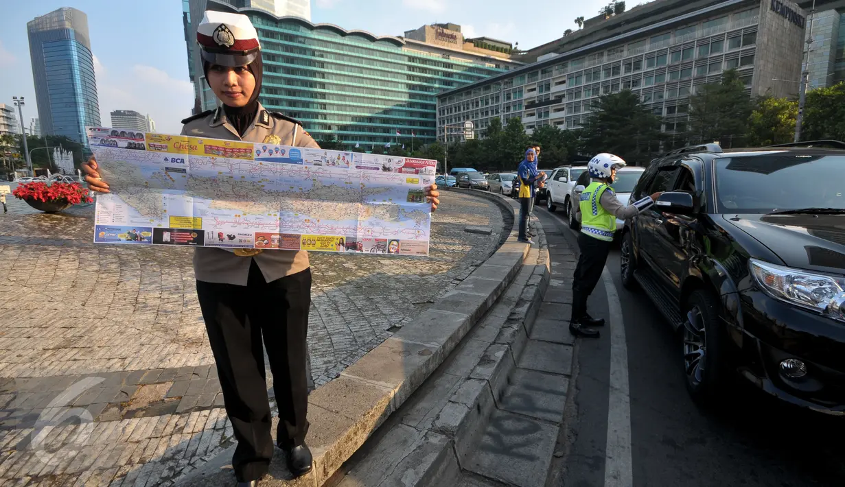 Seorang Polwan membentangkan peta mudik 2015, Jakarta, Jumat (26/6/2015). Pembagian peta tersebut diharapkan mampu meningkatkan keselamatan dalam bermudik. (Liputan6.com/Johan Tallo)