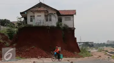 Warga melintas di samping Musala yang masih berdiri di lokasi pembangunan proyek Tol Cinere-Jagorawi di Depok, Jawa Barat, Selasa (1/11). Pembangunan Tol ini masih menyisakan 555 Bidang tanah yang belum dibebaskan. (Liputan6.com/Johan Tallo)