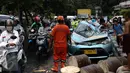 Pengguna jalan mengamati taksi yang ringsek tertimpa pohon tumbang di Jalan Taman Kebon Sirih, Jakarta, Selasa (30/8). Batang pohon itu menimpa kap mesin dan kursi penumpang di samping kemudi taksi bernopol B 1606 TTC. (Liputan6.com/Faizal Fanani)