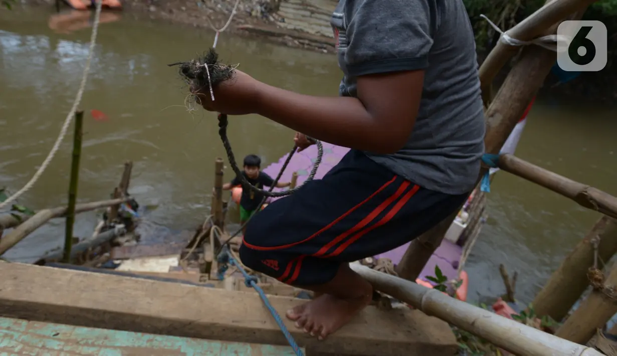 Anak-anak usai menggunakan perahu eretan di sungai Ciliwung, Jakarta, Selasa (3/11/2020). Perahu eretan di sungai Ciliwung masih bertahan sebagai penghubung Jakarta Timur dan Jakarta Selatan Selatan. (merdeka.com/Imam Buhori)