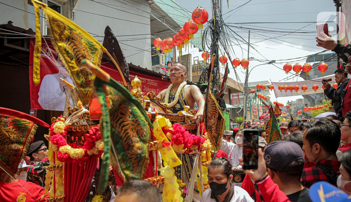 Tatung pria melakukan atraksi dalam Festival Cap Go Meh 2023 di kawasan Glodok, Jakarta, Minggu (5/2/2023). Sebanyak 23 joli atau tandu diarak keliling sebagai penutup rangkaian perayaan Tahun Baru Imlek yang dilaksanakan pada tanggal ke-15 bulan pertama penanggalan Tionghoa. (Liputan6.com/Faizal Fanani)