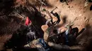 Sejumlah penambang liar sedang menggali untuk mencari emas dan batu ruby di tambang Gemfields di Montepuez, Mozambik (14/2). (AFP/John Wessels)